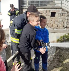 Zwei Jungs testen den Feuerwehrschlauch
